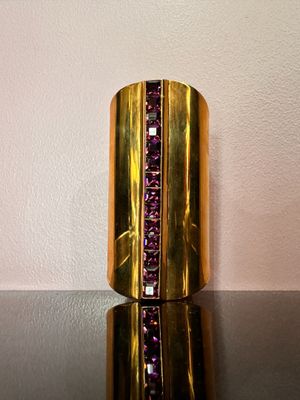 bracelet manchette violet et doré, orné de pierres violettes sur un fond noir