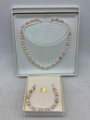 une boîte blanche contenant un collier et une paire de perles