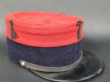 une image représentant un chapeau rouge et bleu posé sur une table noire