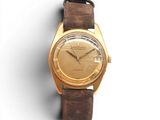 une image d'une montre-bracelet en or avec un bracelet en cuir marron