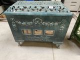 a green metal box sitting on the floor next to a green cabinet