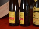 three bottles of wine sitting on a table next to a wooden block