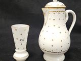 une cafetière blanche et une tasse sur fond noir