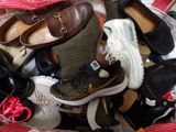 many pairs of shoes in a basket on the floor