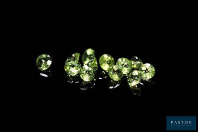 a group of green gems sitting on top of a black surface
