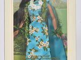 La poupée se trouve dans une boîte décorée d'une robe bleue et de fleurs.