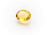 a yellow sapphire stone on a white background