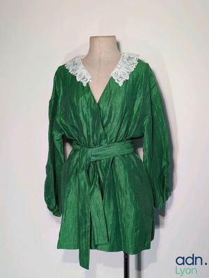 green dress with white lace collar on a mannequin dummy