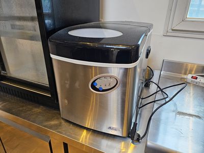 une petite machine à glaçons posée sur un plan de travail dans une cuisine