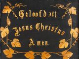 an old black and gold plaque with a vine design on it