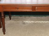 une table en bois avec un plateau en verre et deux tiroirs