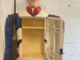 a statue of a soldier holding a chest with a door open