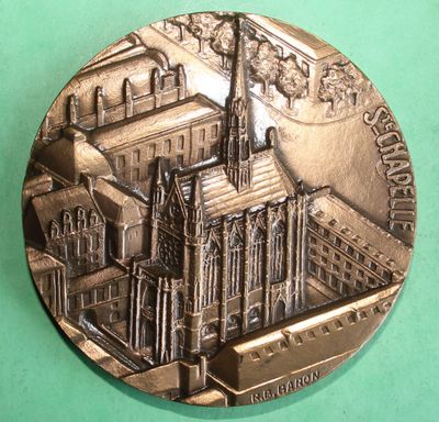 a silver medal with a picture of a building on it