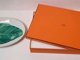 une boîte orange avec une feuille verte posée sur une assiette à côté