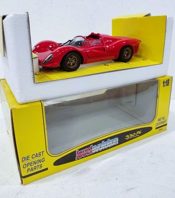 une petite voiture rouge dans une boîte jaune posée sur une surface blanche