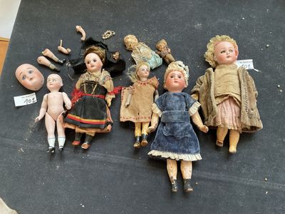 several antique dolls are lined up on a black surface