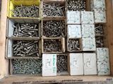 many boxes of screws in a box on the floor