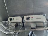 two electric fryers sitting on a counter in a kitchen