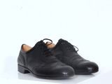 une paire de chaussures noires posée sur une surface blanche