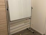 a dry eraser board in the corner of a room