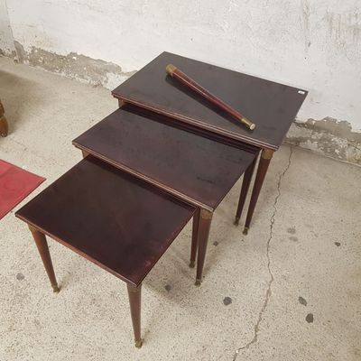 trois tables posées à même le sol en béton