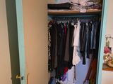 une armoire pleine de vêtements et un radiateur dans un coin de la pièce