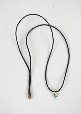 un cordon noir avec une perle verte, un cordon noir avec une perle verte et un cordon noir avec une perle verte