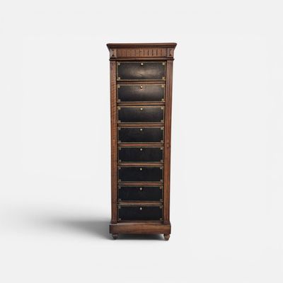 une grande commode en bois à cinq tiroirs avec un plateau noir