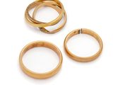 three gold wedding rings on a white background