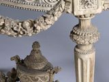 a white table with a marble top and ornate carvings on it