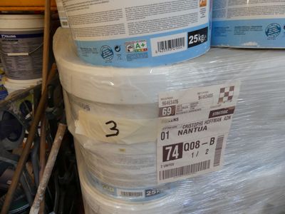 plusieurs seaux de peinture sont empilés les uns sur les autres