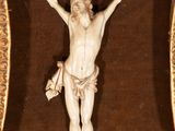 a statue of jesus on the cross in a gold frame