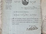 an old document sitting on top of a wooden table next to a pair of scissors