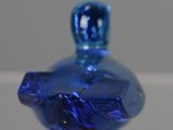 a blue glass perfume bottle sitting on top of a table