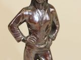 a bronze statue of a woman standing on a black base