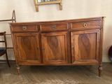 une armoire en bois à deux portes et un miroir accroché au mur
