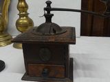 a small coffee grinder sitting on a table next to a lamp