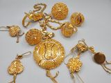 quelques bijoux en or sont posés sur une surface blanche