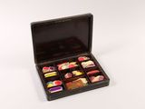 a black box filled with assorted candys on a white surface