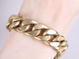 a close up of a person ' s hand wearing a gold chain bracelet