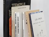 several books are stacked on top of each other on a white surface