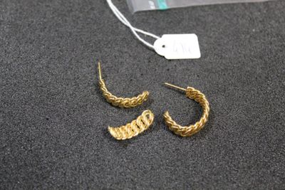a close up of a pair of gold earrings on a table