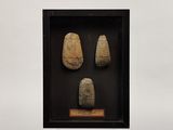 a display case with three pieces of stone in it