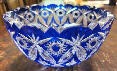 une photo représentant un bol en verre bleu posé sur une table en bois