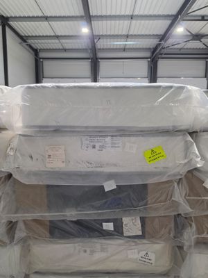 many mattresses stacked on top of each other in a warehouse