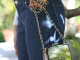 someone is holding a small purse with a chain around it