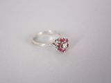 un gros plan d'une bague en argent sertie de pierres roses