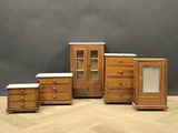 quatre meubles posés sur un parquet, près d'un mur gris