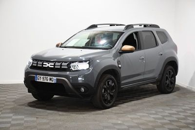 La Dacia grise est garée dans une pièce au sol carrelé en damier.