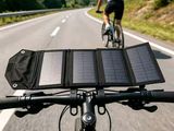 a person riding a bike with a solar panel on the handlebars